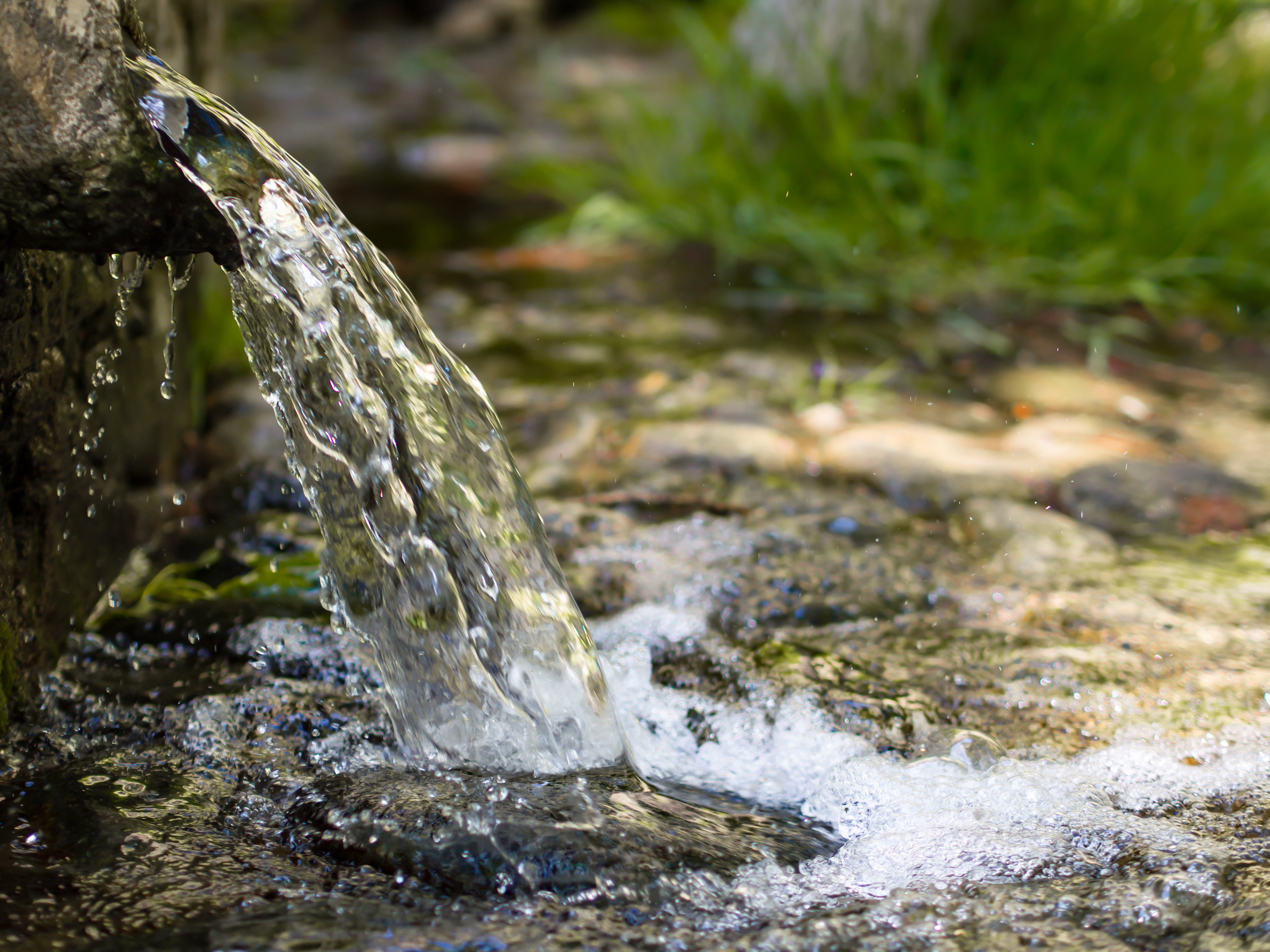 Natural Water Pouring From a Pipe to a Stream